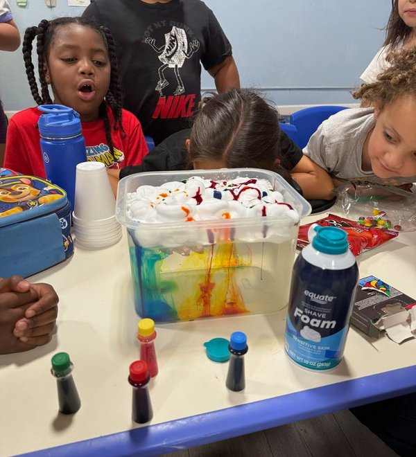 Children exploring a colorful science activity together at a classroom table