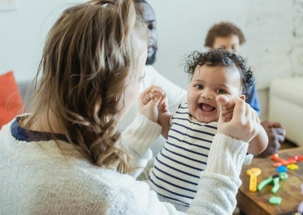 Caregiver holding a smiling baby in the infant room