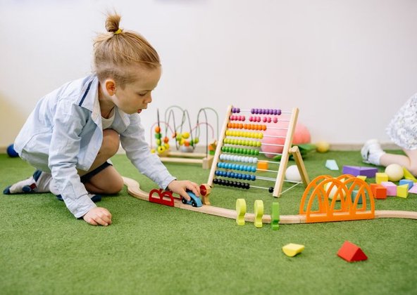 Preschool children playing together with colorful blocks